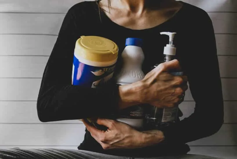 woman in black long sleeve shirt holding white and yellow plastic bottle