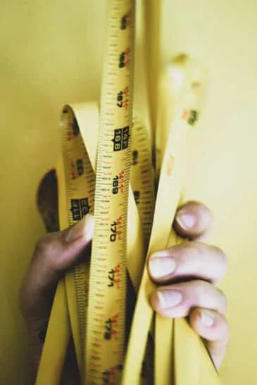 person holding yellow steel tape measure